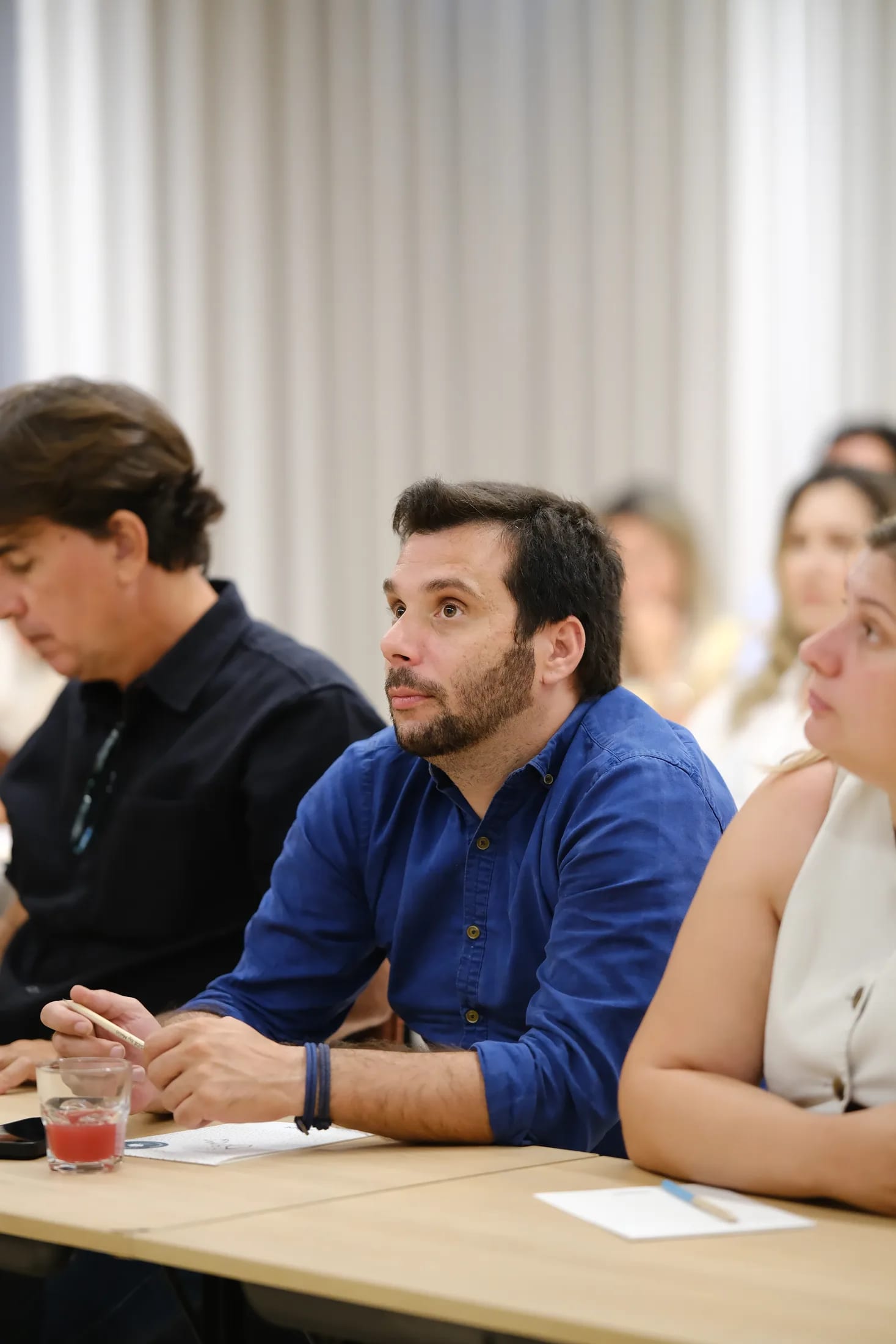 Participante toma notas durante uma sessão presencial